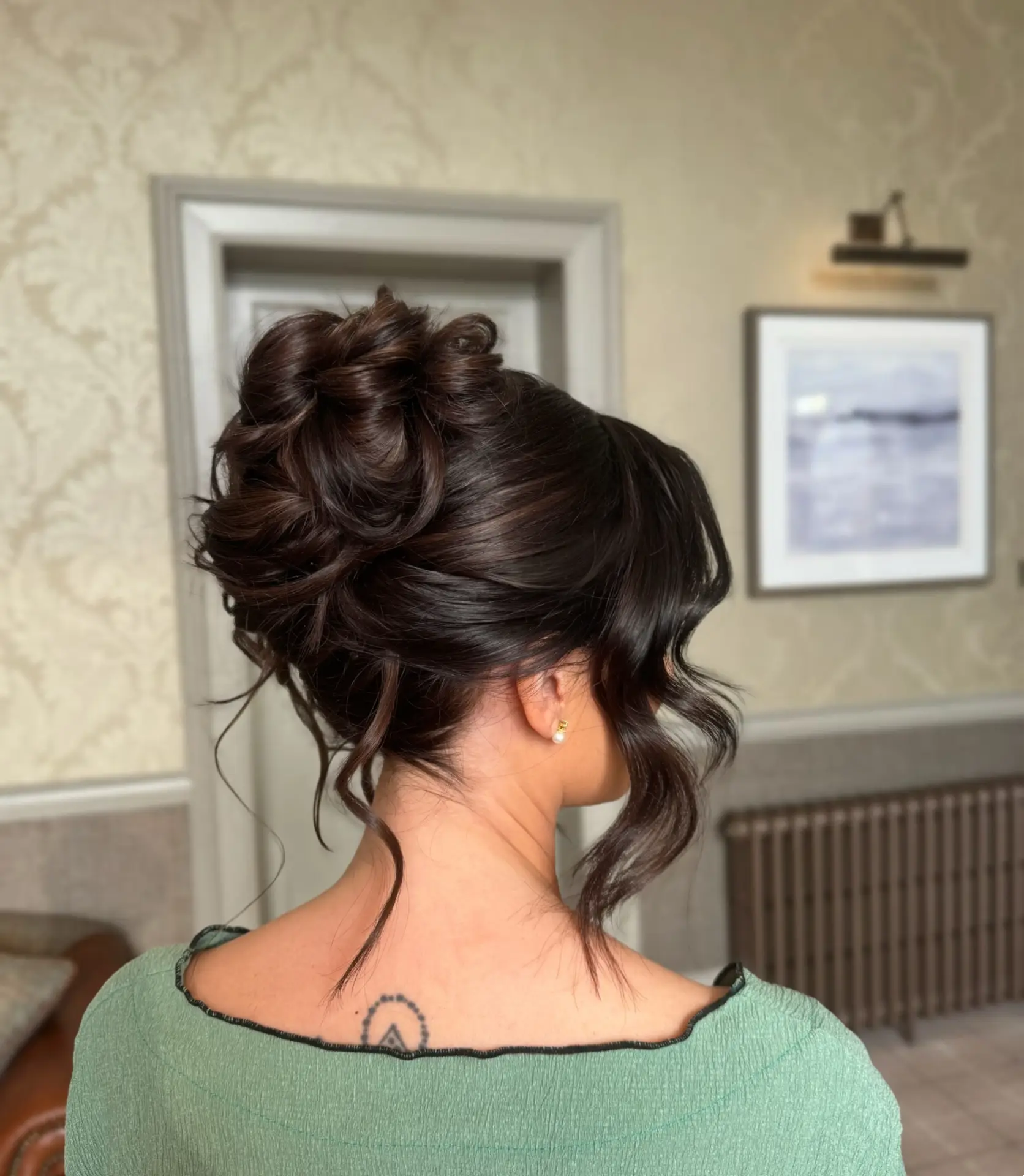 Textured High Bun with Soft Curled Face Framing Pieces