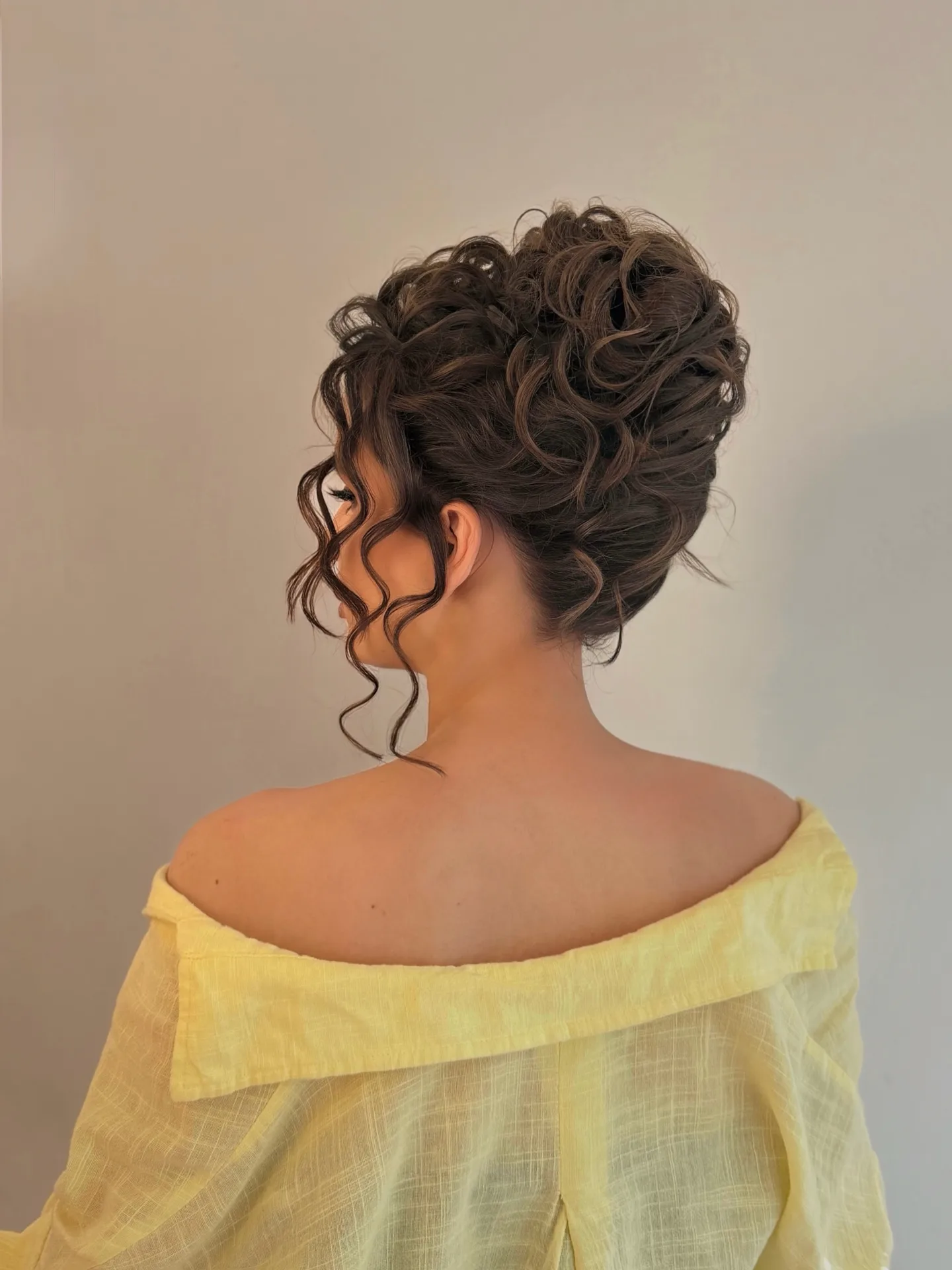 Voluminous Curly Updo with Soft Face Framing Curls